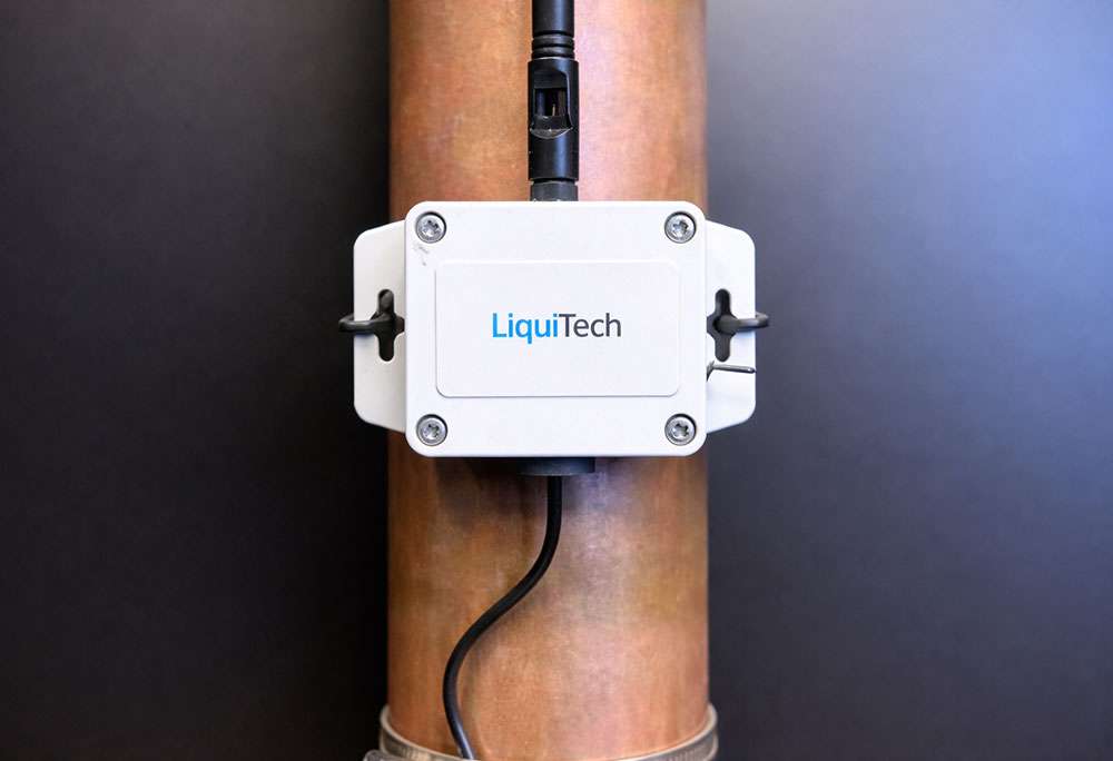 LiquiTech Smart Sensor mounted on a copper pipe for non-invasive real-time water temperature and flow monitoring