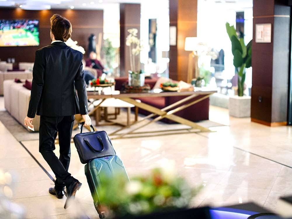Business traveler walking through a upscale hotel lobby on the LiquiTech Hospitality page
