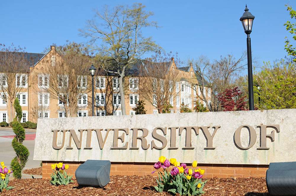 University campus entrance sign and historic brick academic building on the LiquiTech Education page