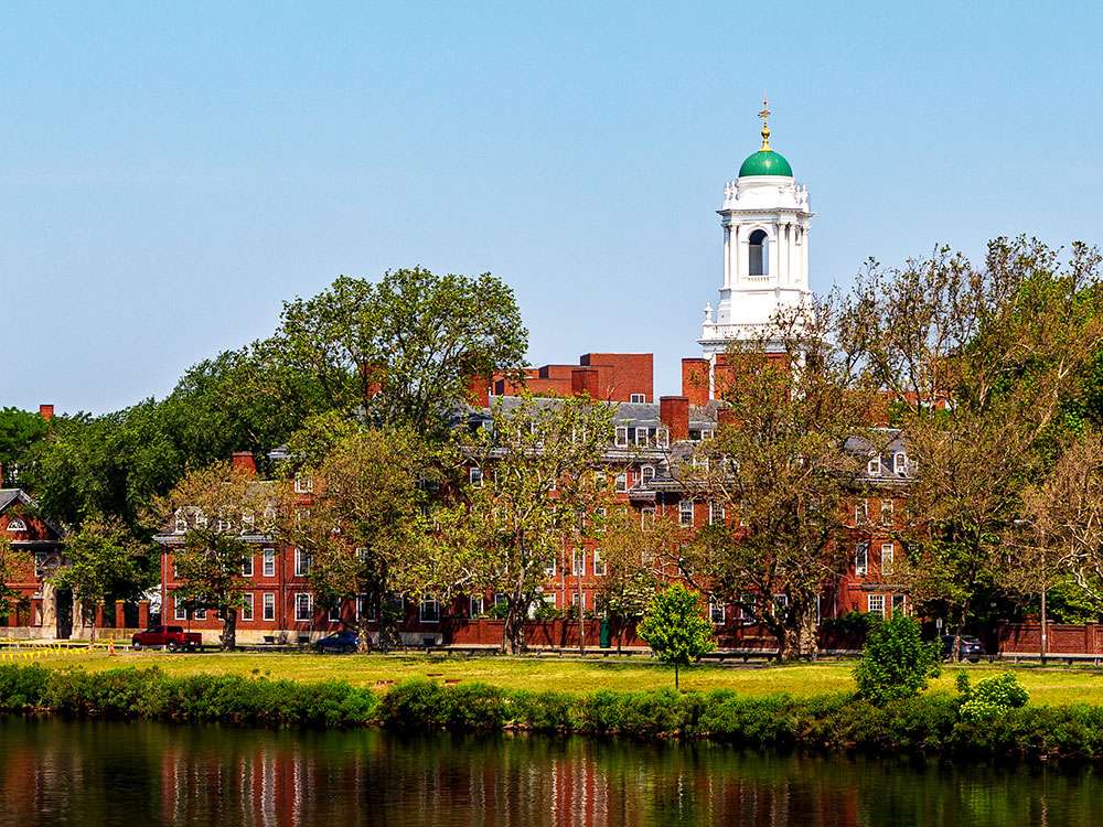 Historic university campus buildings along a river, featured in the LiquiTech Northeast University Sediment Filtration case study